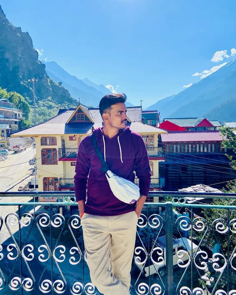 Rishabh in a mountain village in Spiti Valley with Himalayan peaks in the background